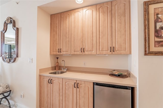 kitchen featuring sink, light brown cabinets, and refrigerator