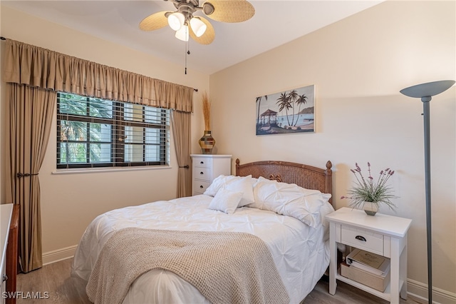 bedroom with dark hardwood / wood-style flooring and ceiling fan