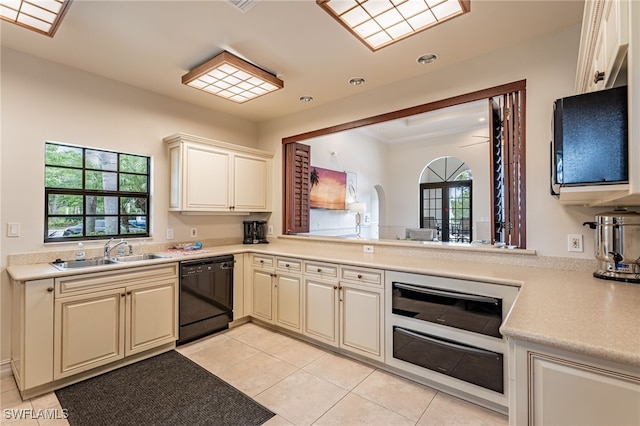 kitchen featuring cream cabinetry, dishwasher, sink, and light tile patterned floors