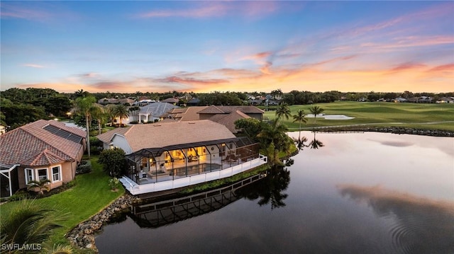 aerial view at dusk featuring a water view