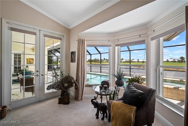 sitting room with lofted ceiling, ornamental molding, light colored carpet, and french doors