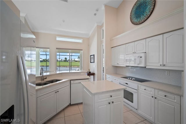 kitchen featuring sink, white appliances, a center island, and white cabinets