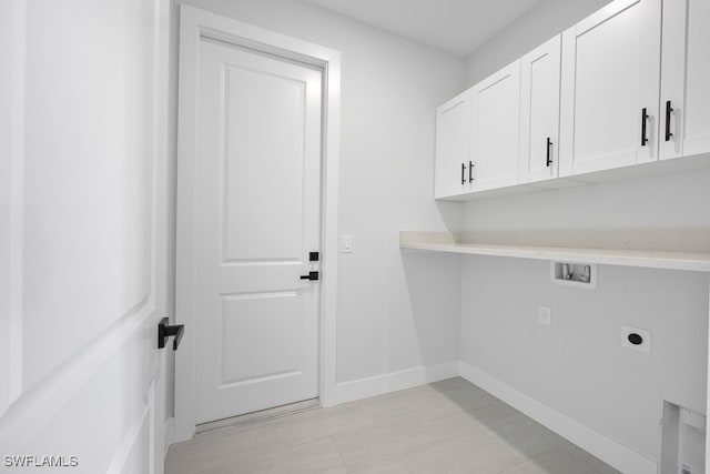 washroom featuring hookup for an electric dryer, cabinets, washer hookup, and light tile patterned floors