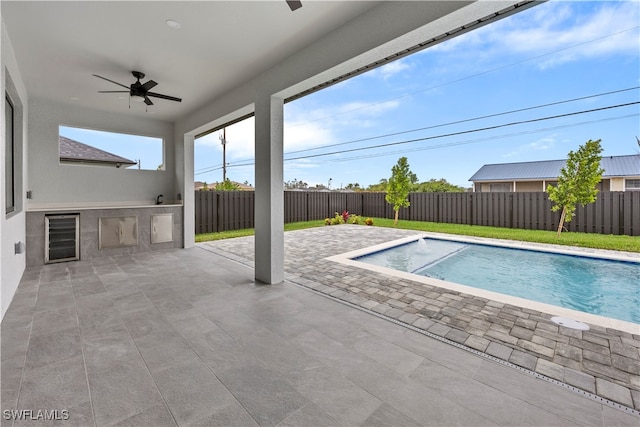 view of swimming pool with ceiling fan and a patio