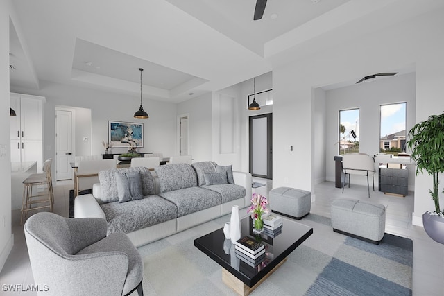 living room with ceiling fan and a raised ceiling