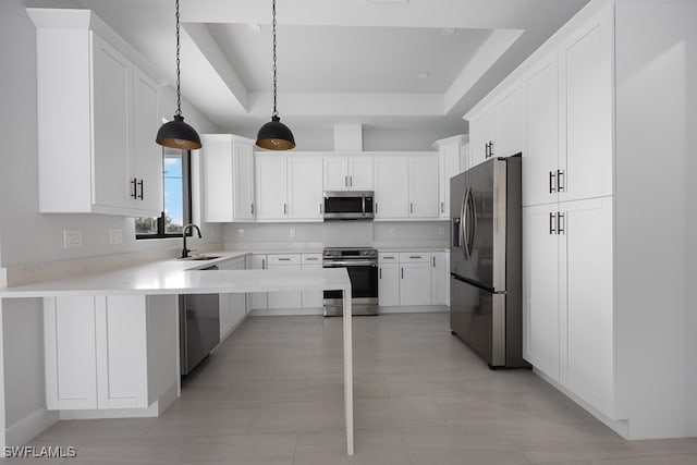 kitchen featuring a raised ceiling, appliances with stainless steel finishes, light tile patterned floors, sink, and decorative light fixtures