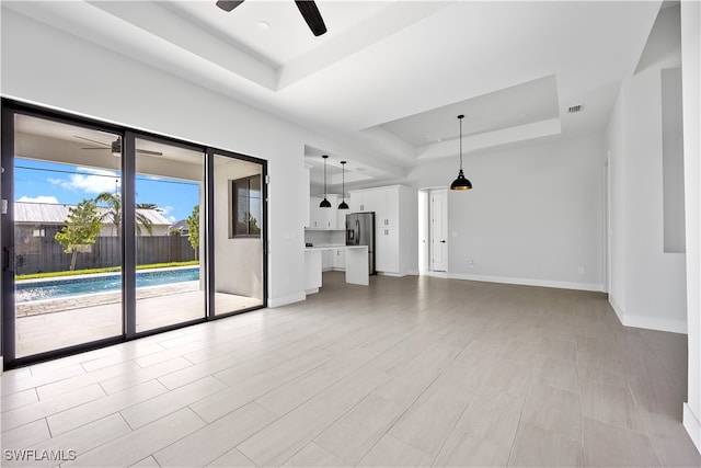 spare room featuring ceiling fan and a raised ceiling