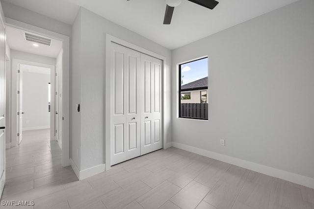 unfurnished bedroom featuring ceiling fan and a closet