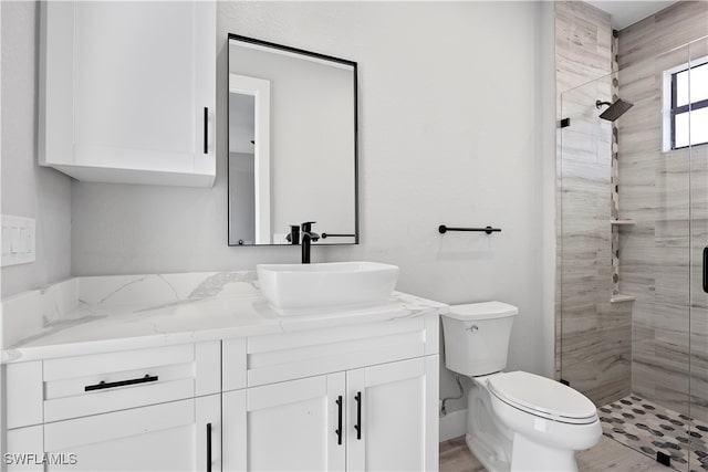 bathroom featuring vanity, toilet, and tiled shower