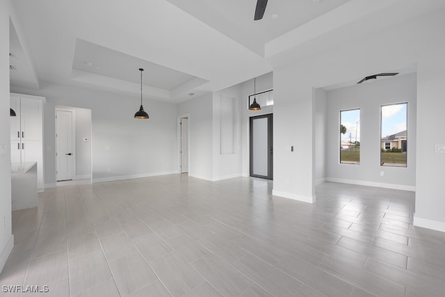 tiled spare room with a raised ceiling