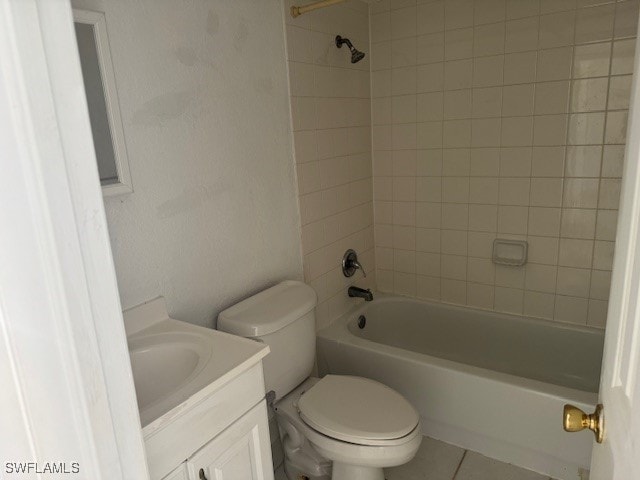 full bathroom with tiled shower / bath combo, vanity, tile patterned floors, and toilet