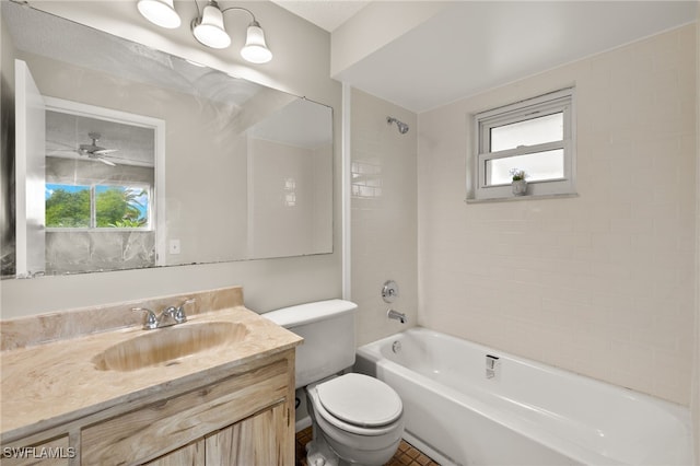 full bathroom with ceiling fan, toilet, vanity, and tiled shower / bath