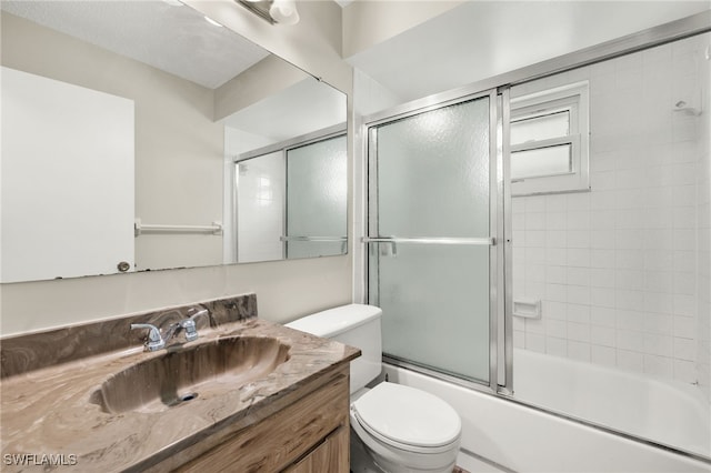 full bathroom featuring toilet, enclosed tub / shower combo, and vanity