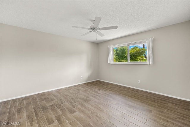 empty room featuring hardwood / wood-style flooring, a textured ceiling, and ceiling fan