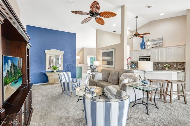 carpeted living room featuring high vaulted ceiling and ceiling fan