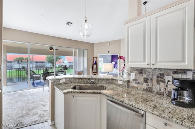 kitchen featuring dishwasher, sink, white cabinets, decorative backsplash, and light stone counters