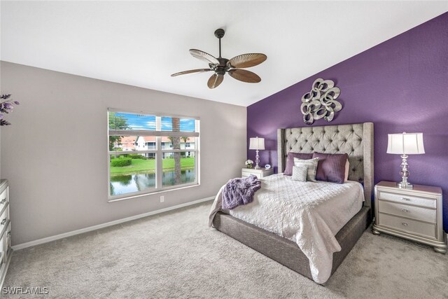 carpeted bedroom with ceiling fan and vaulted ceiling