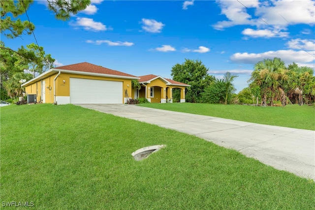 view of front of house with a garage, a front yard, and central AC unit