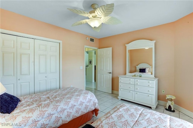 bedroom featuring a ceiling fan, a closet, baseboards, and light tile patterned floors