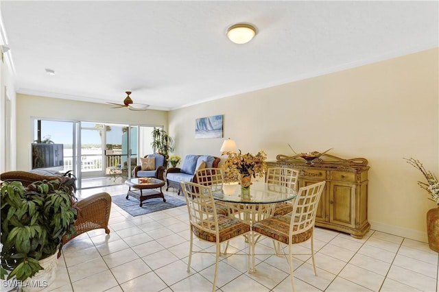 dining space with baseboards, a ceiling fan, crown molding, and light tile patterned flooring