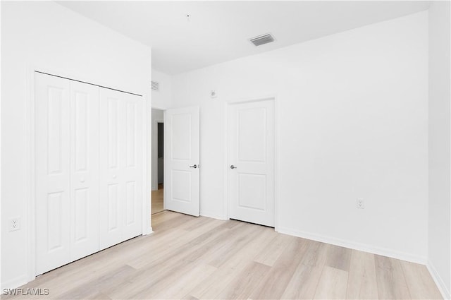 unfurnished bedroom featuring a closet and light hardwood / wood-style flooring