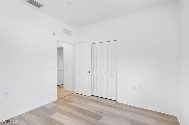 unfurnished bedroom featuring light hardwood / wood-style floors and a closet