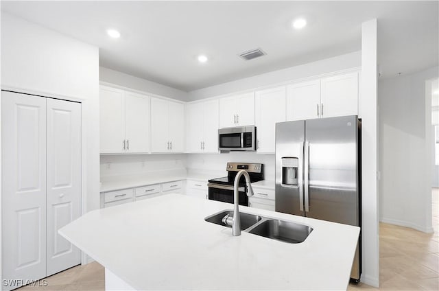 kitchen featuring sink, an island with sink, white cabinets, and appliances with stainless steel finishes