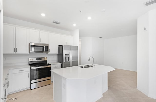 kitchen featuring sink, white cabinetry, light tile patterned floors, stainless steel appliances, and a kitchen island with sink