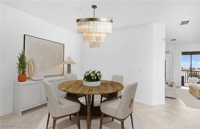 tiled dining area featuring an inviting chandelier