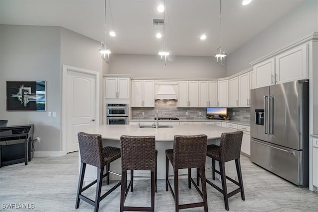 kitchen featuring a kitchen island with sink, appliances with stainless steel finishes, and white cabinetry