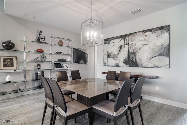 dining space with baseboards, visible vents, and a notable chandelier