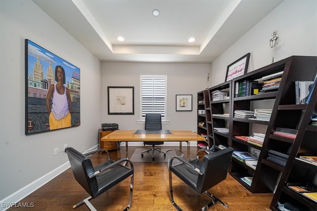 office area featuring hardwood / wood-style flooring and a tray ceiling