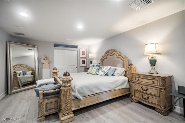 bedroom with baseboards, a closet, visible vents, and light wood-style floors