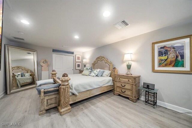 bedroom with light wood-style floors, baseboards, and visible vents