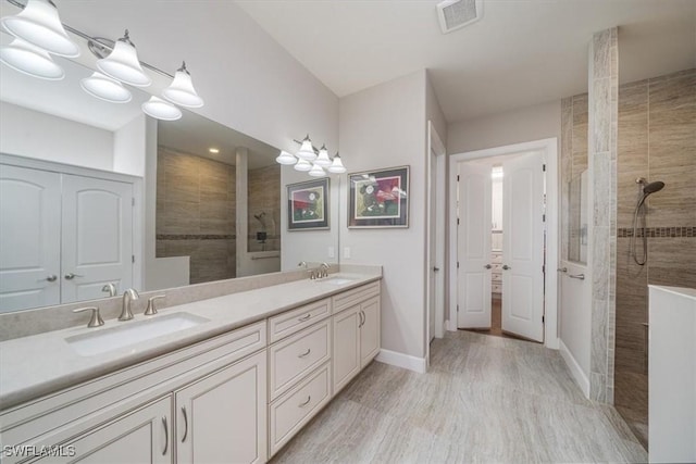 full bathroom with visible vents, a sink, and walk in shower