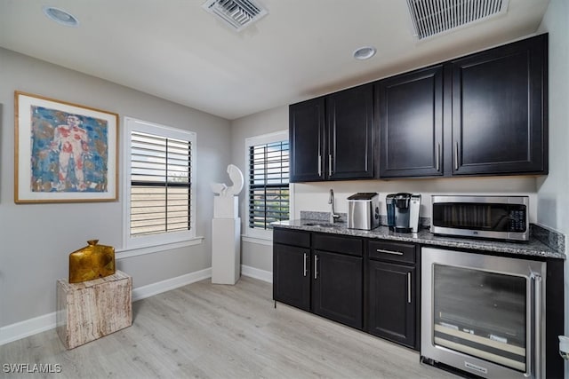 kitchen with beverage cooler, sink, and light hardwood / wood-style floors