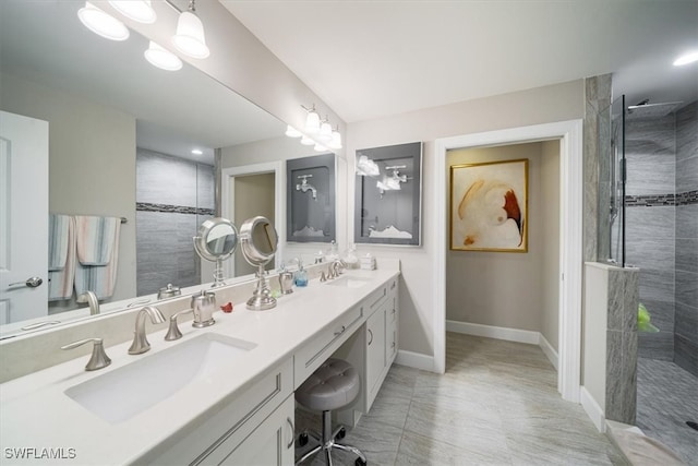 bathroom with vanity and tiled shower