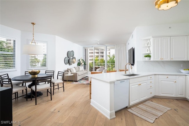 kitchen featuring sink, white cabinetry, decorative light fixtures, dishwasher, and kitchen peninsula