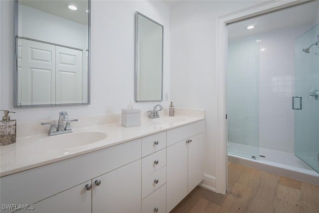 bathroom with vanity, hardwood / wood-style floors, and a shower with shower door