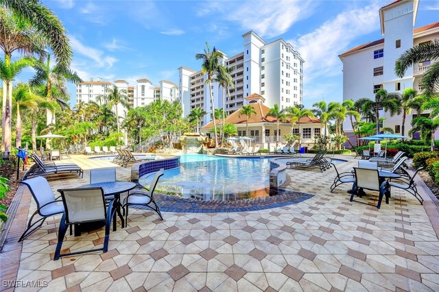 view of swimming pool with pool water feature and a patio