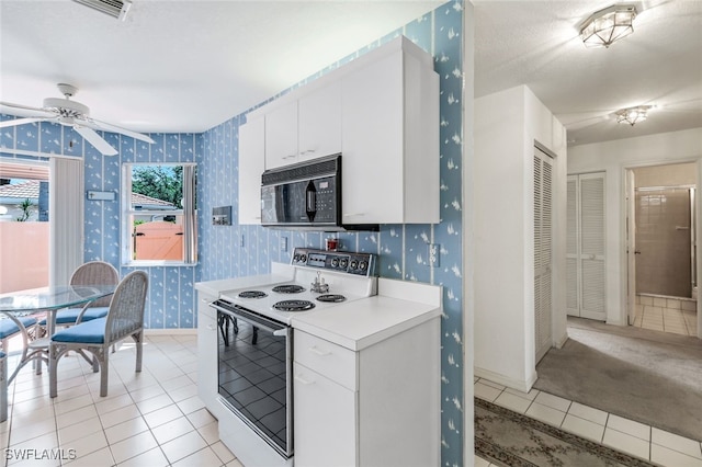 kitchen with white cabinetry, light tile patterned floors, electric range, and ceiling fan