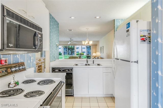 kitchen featuring sink, white cabinetry, hanging light fixtures, kitchen peninsula, and black appliances