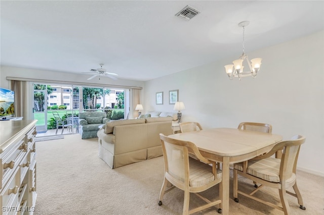 carpeted dining room featuring ceiling fan with notable chandelier