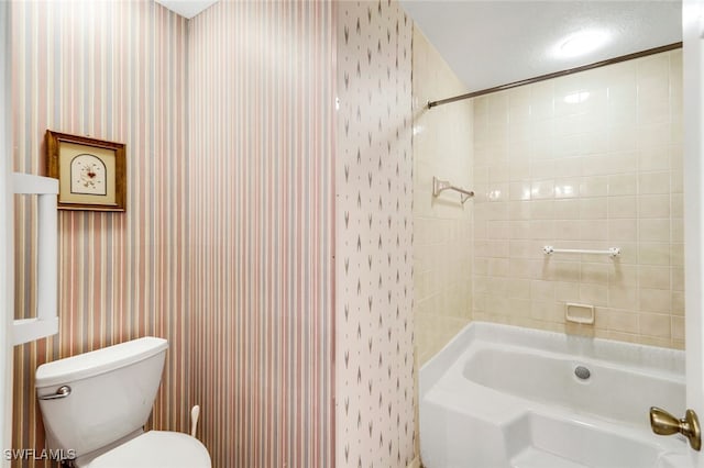 bathroom featuring tiled shower / bath and toilet