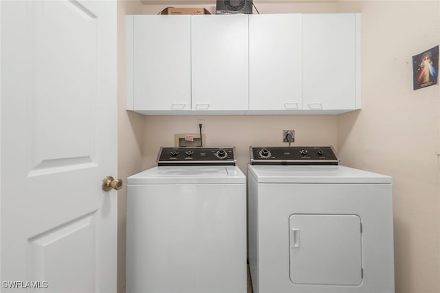 washroom with cabinets and washer and dryer