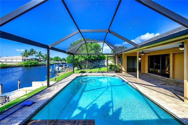 view of pool featuring a lanai, a patio area, a water view, and ceiling fan