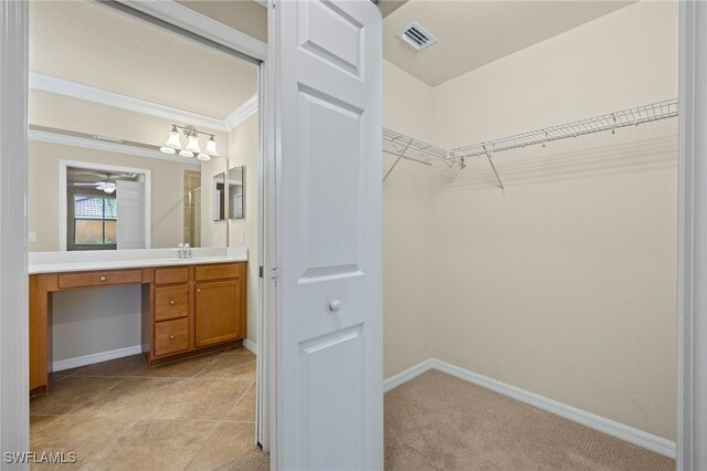 spacious closet with ceiling fan and light tile patterned floors