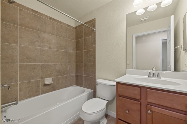 full bathroom featuring tiled shower / bath combo, toilet, and vanity