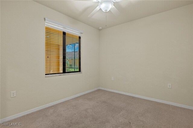 carpeted spare room featuring ceiling fan