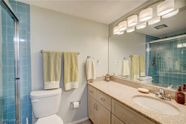 bathroom featuring toilet, a shower with door, and vanity